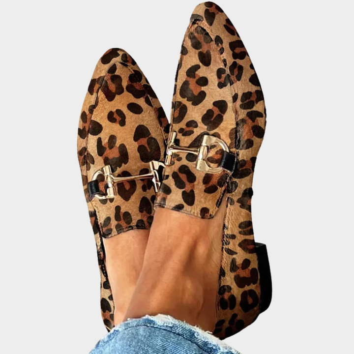 A woman wearing leopard print slip-on loafers, styled for an easy day in the city.
