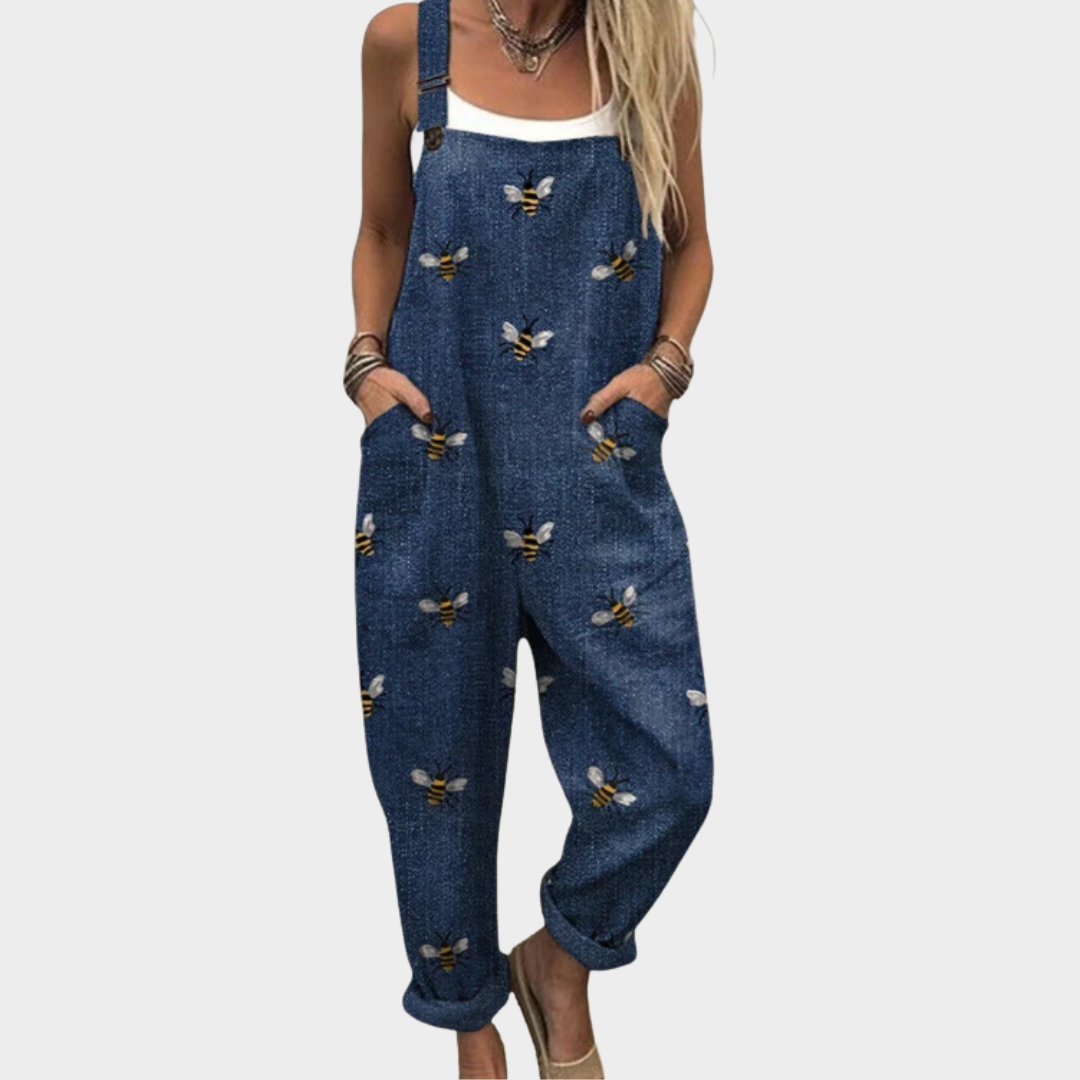 Woman wearing navy overalls with a scattered golden bee print, adjustable straps, cheerful and relaxed.