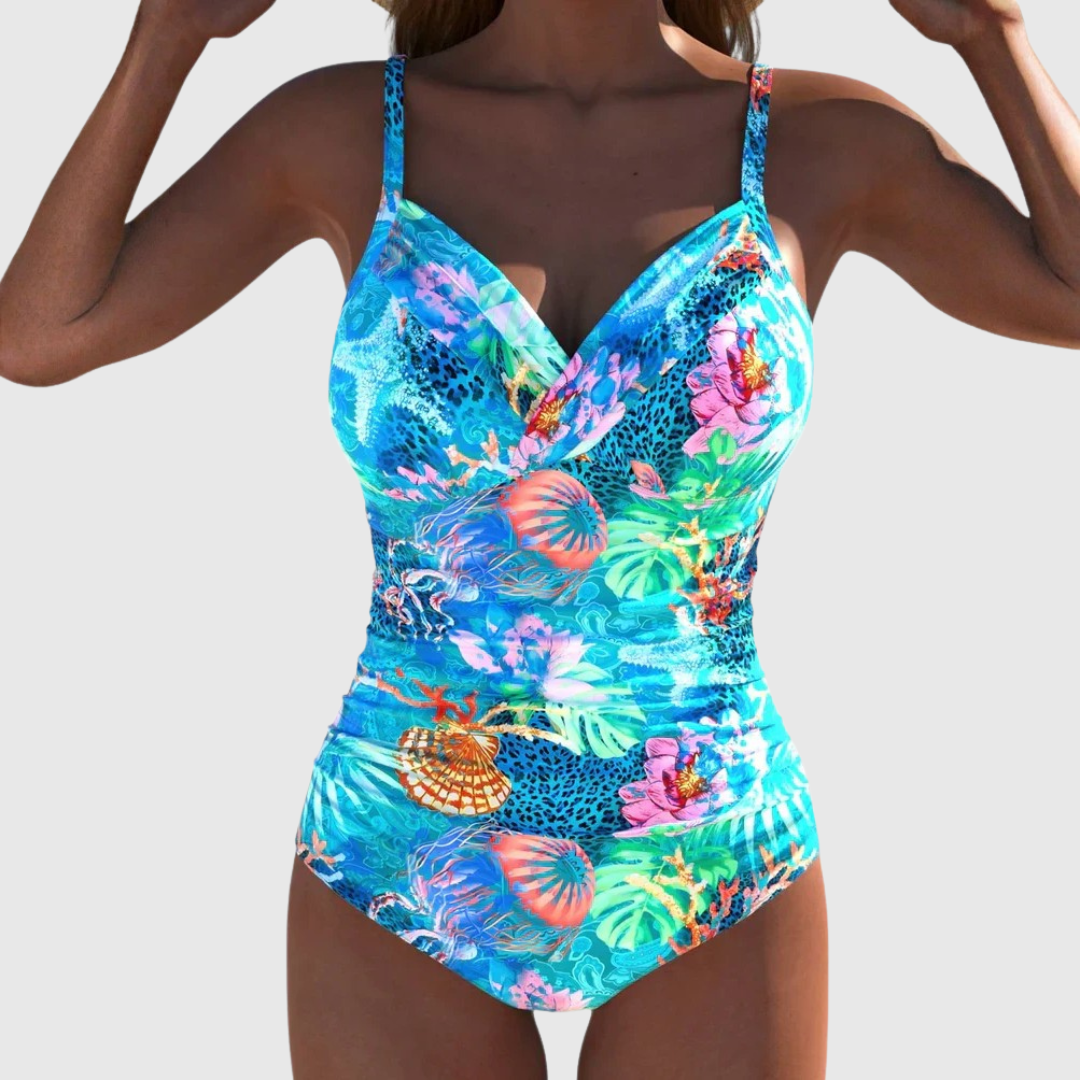 A woman wearing an elegant swimsuit with a fresh print, confident and relaxed by the water.