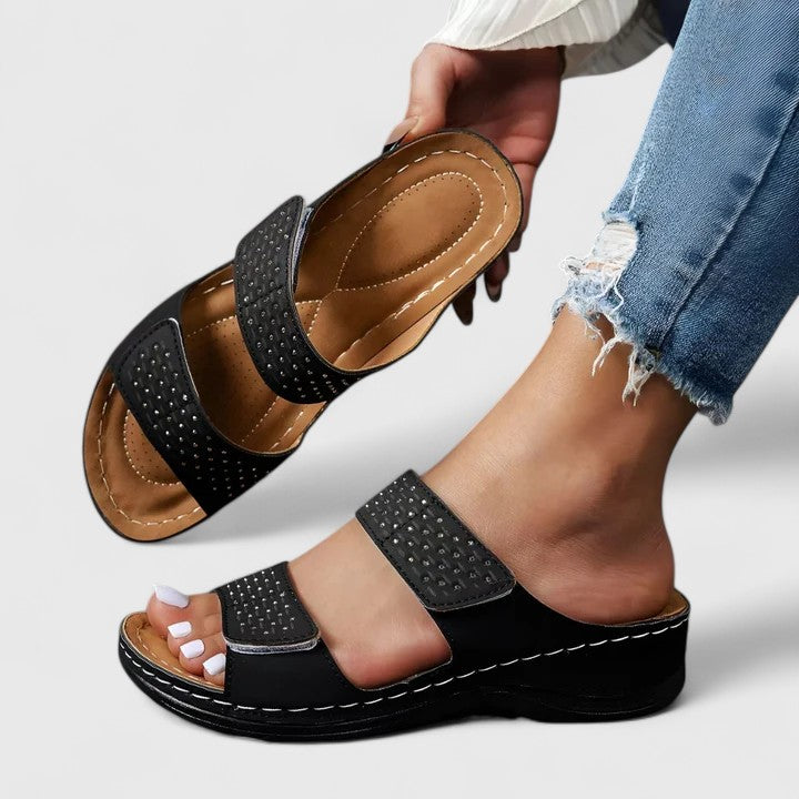 A woman walking comfortably in open-toe wide-fit orthopaedic sandals with a cushioned footbed.