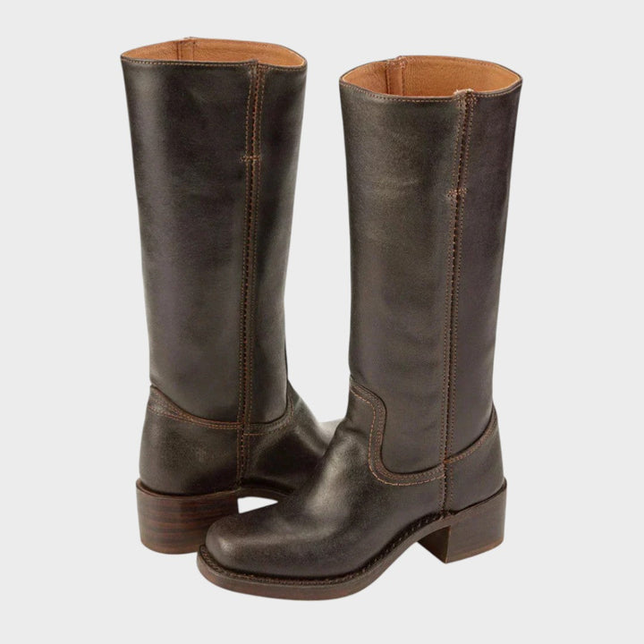 A woman wearing tall classic riding boots with jeans on a country walk.