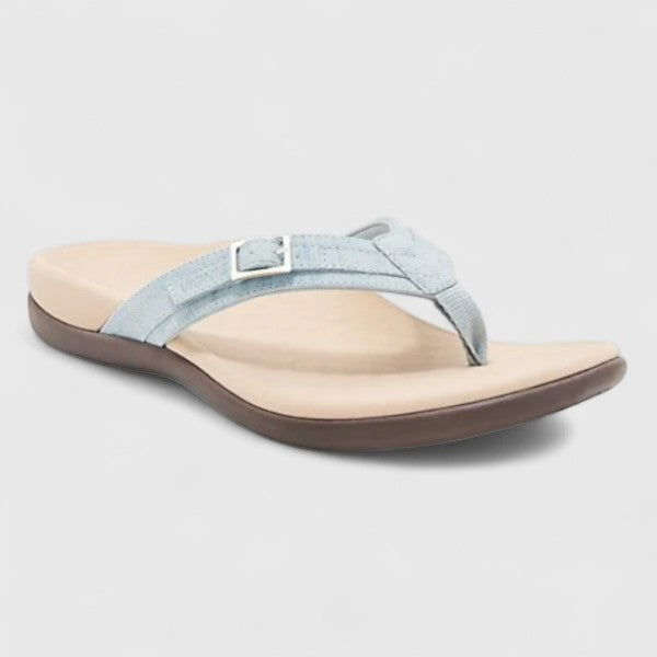 A woman in light blue lightweight flip-flops relaxing on a sunny terrace, feet light and comfortable.