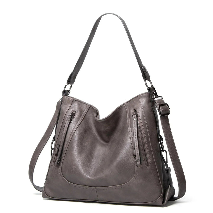 A woman wearing a crisp white elegant shoulder bag over her shoulder at an afternoon event.