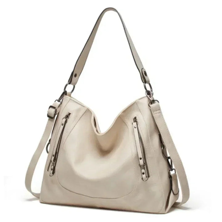 A woman wearing a crisp white elegant shoulder bag over her shoulder at an afternoon event.