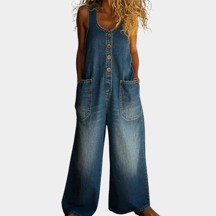 A woman wearing light blue wide-leg vintage overalls with a buttoned front and roomy patch pockets.