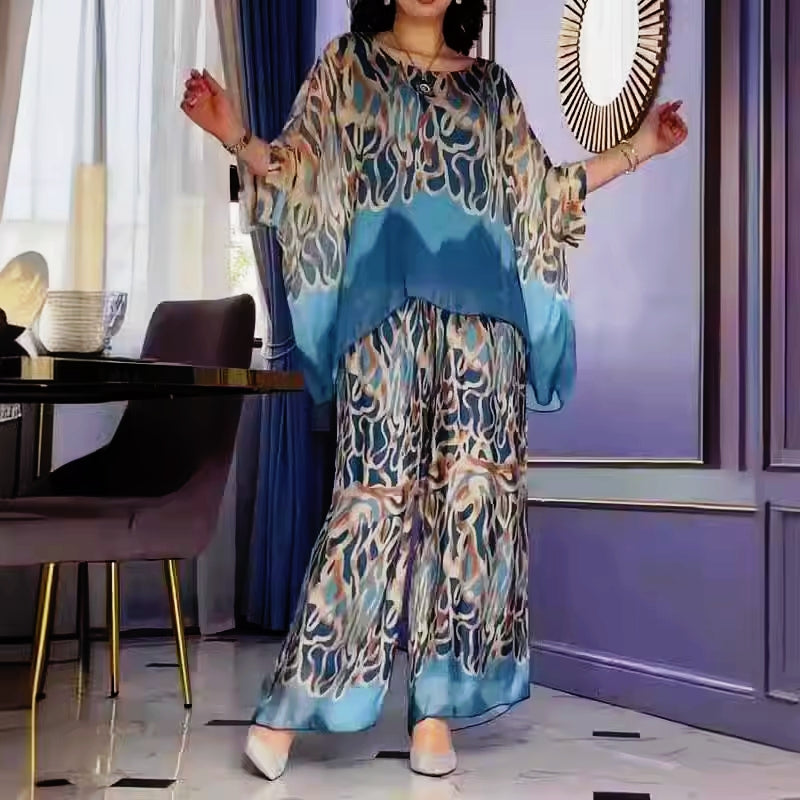 A woman wearing a flowing abstract-print two-piece set with wide-leg pants
