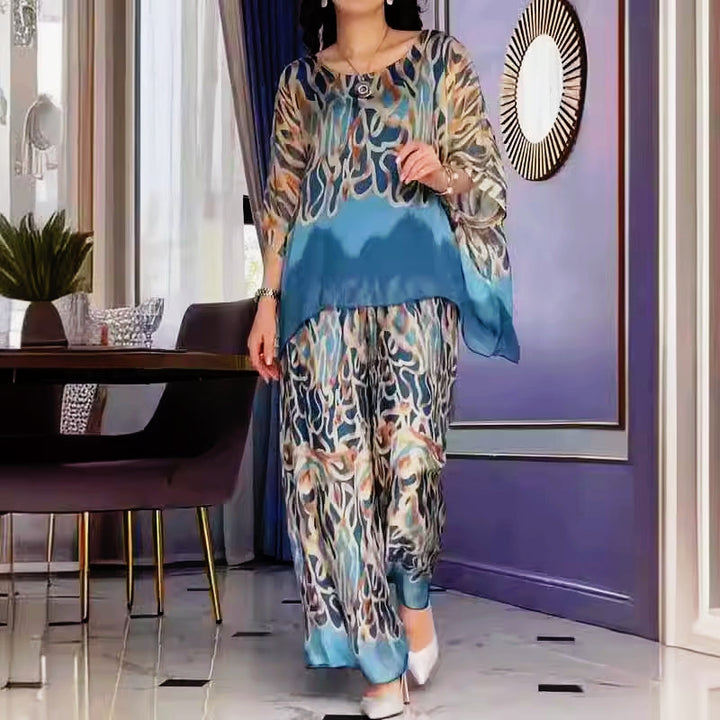 A woman wearing a flowing abstract-print two-piece set with wide-leg pants