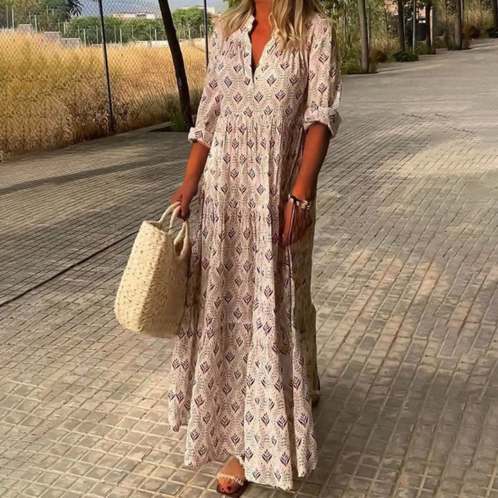 Woman wearing the Monica™ elegant boho maxi dress with a V-neckline and flowing skirt at a summer occasion.