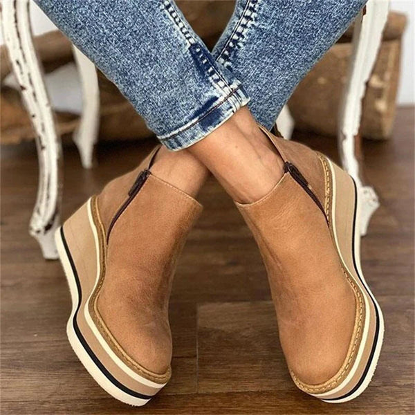 A woman wearing sleek minimalist ankle boots with jeans on a city break.