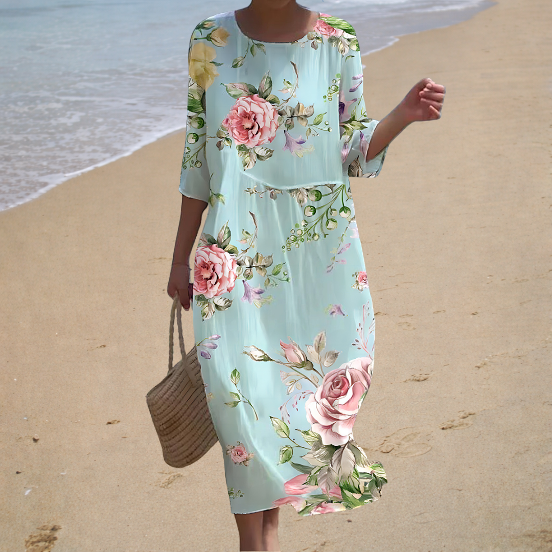 A woman wearing a long, flowing summer dress with an elegant pattern, the hem moving softly as she walks.