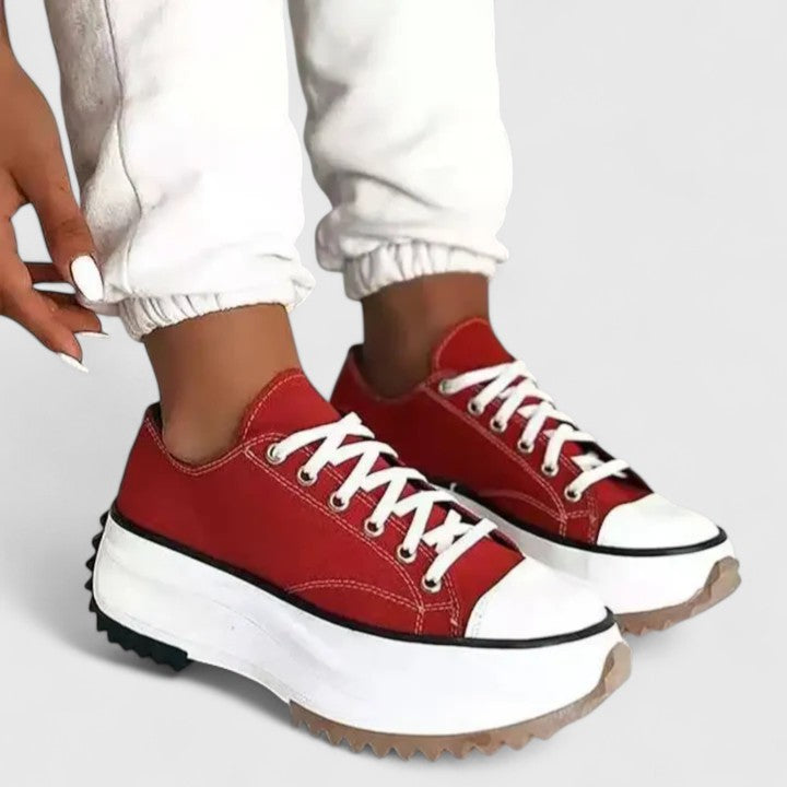 A woman in bold lace-up platform comfort sneakers styled with jeans.