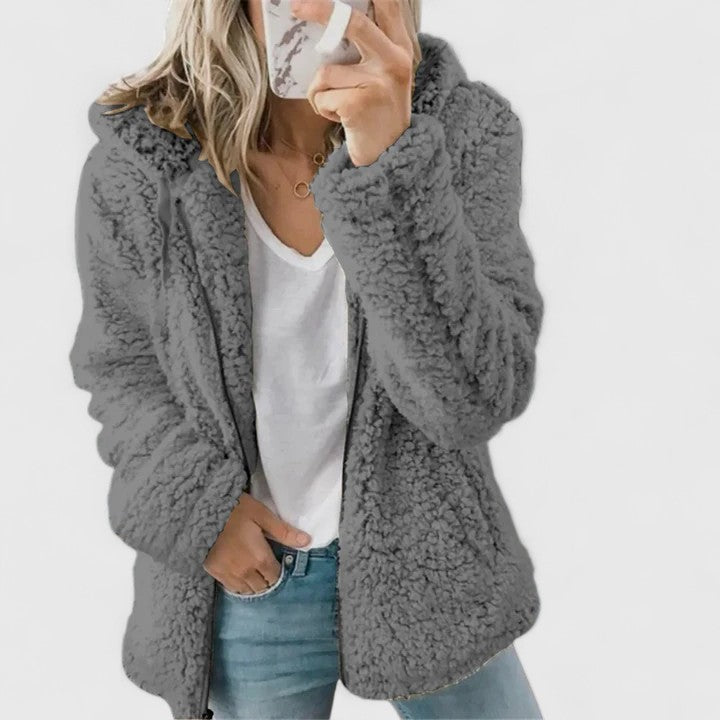 A woman wearing a plush cosy zip jacket over jeans on a cold winter morning.