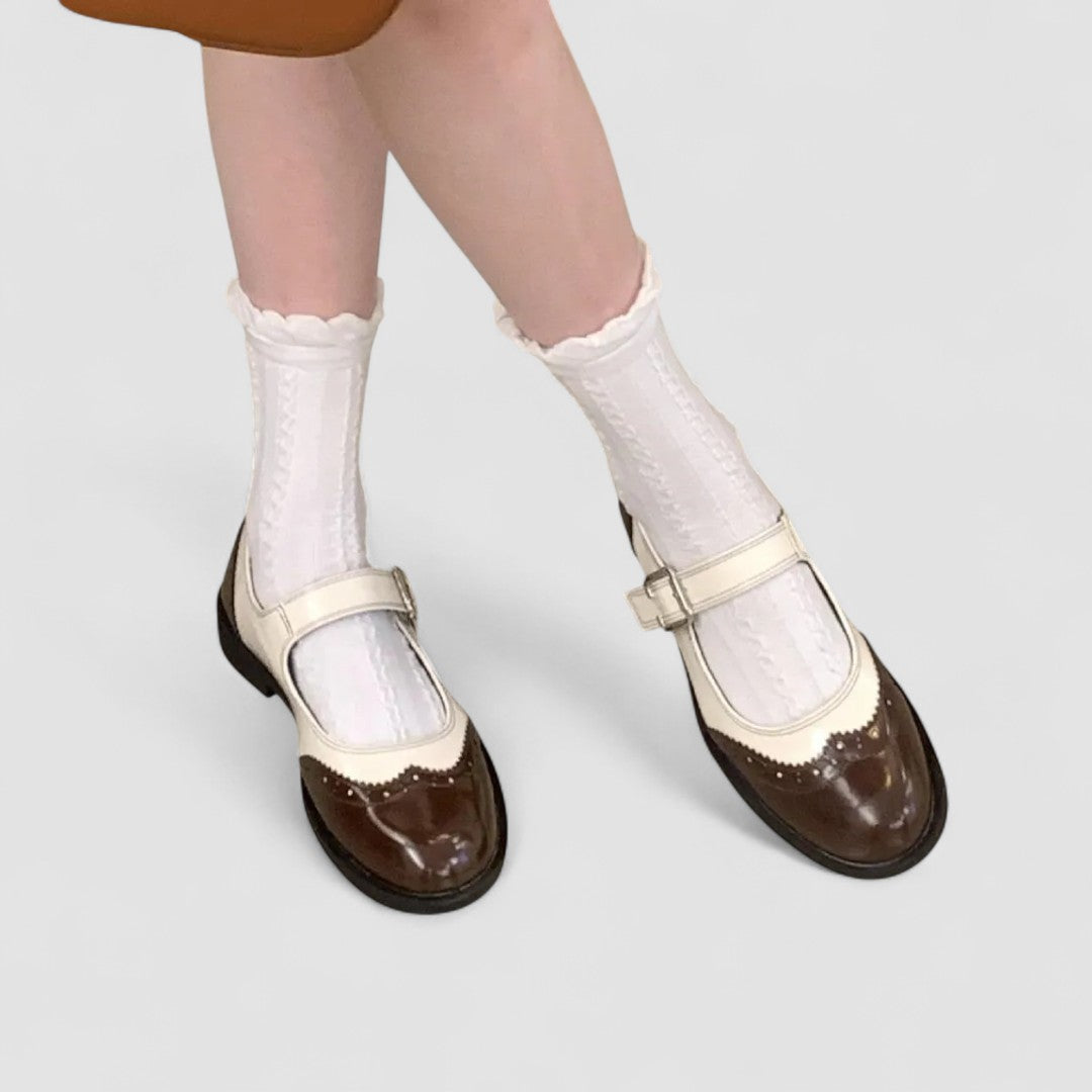 A woman wearing two-tone black and cream Mary Jane shoes, steady and comfortable on an evening out.