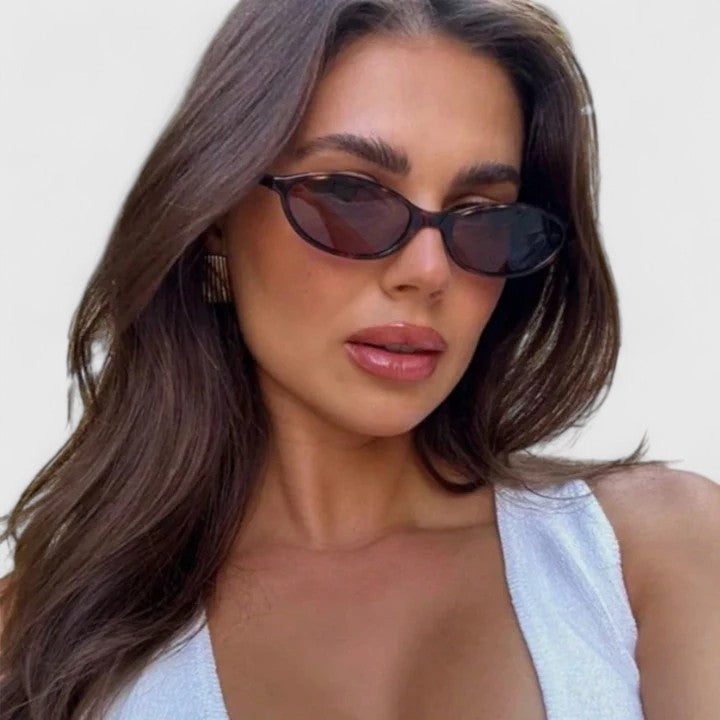 A woman wearing retro oval cat-eye sunglasses on a sunny afternoon.