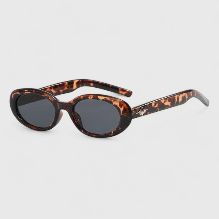A woman in the city wearing chic oval sunglasses, confident and stylish in the sun.