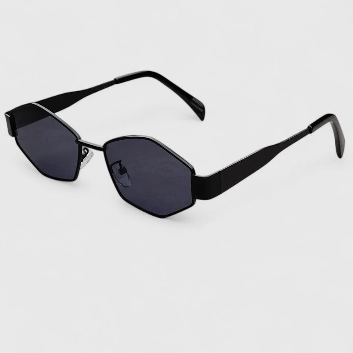 A woman wearing retro hexagonal metal-frame sunglasses on a sunny street.