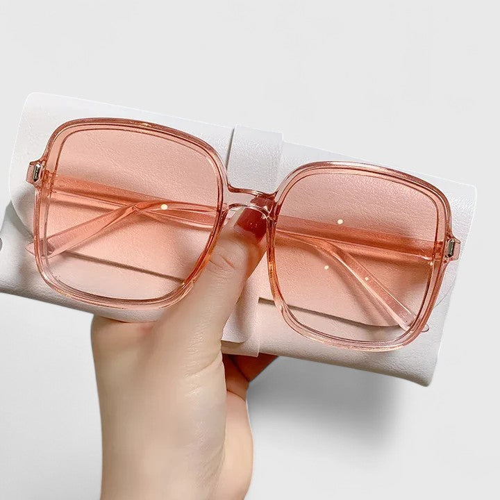 A woman wearing vintage-inspired oversized sunglasses in the sun, elegant and relaxed.