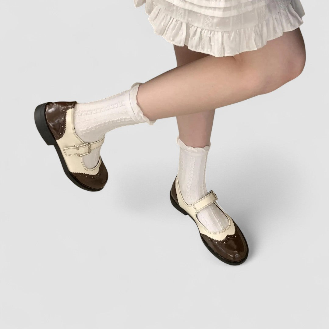 A woman wearing two-tone black and cream Mary Jane shoes, steady and comfortable on an evening out.
