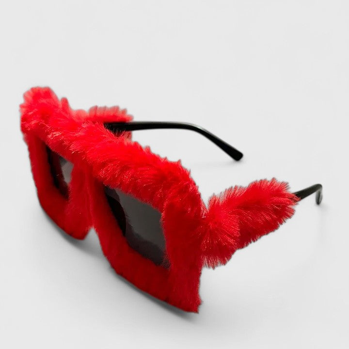 A bold pair of sunglasses with a soft red fluffy trim around the frame and slim black arms.