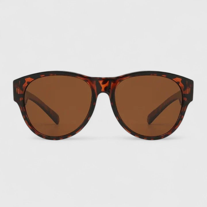 A woman wearing fit-over polarised sunglasses over her own glasses, comfortable in the sunshine.
