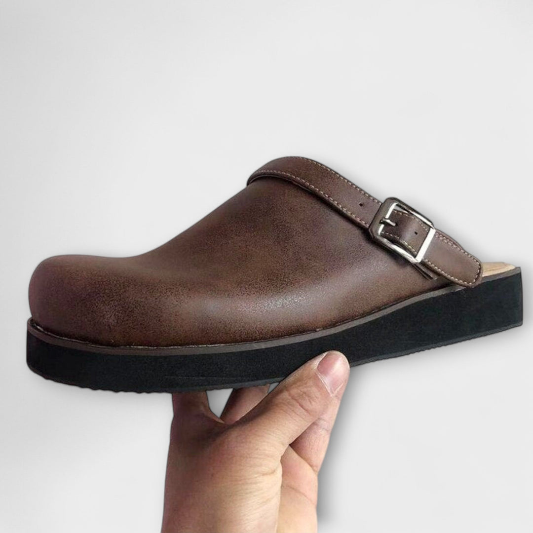 A woman wearing brown platform clogs with an adjustable strap on a market morning.