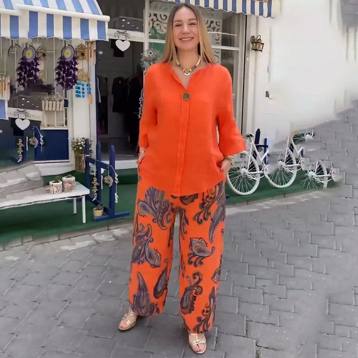 A woman wearing a bright blue blouse with matching patterned wide-leg pants