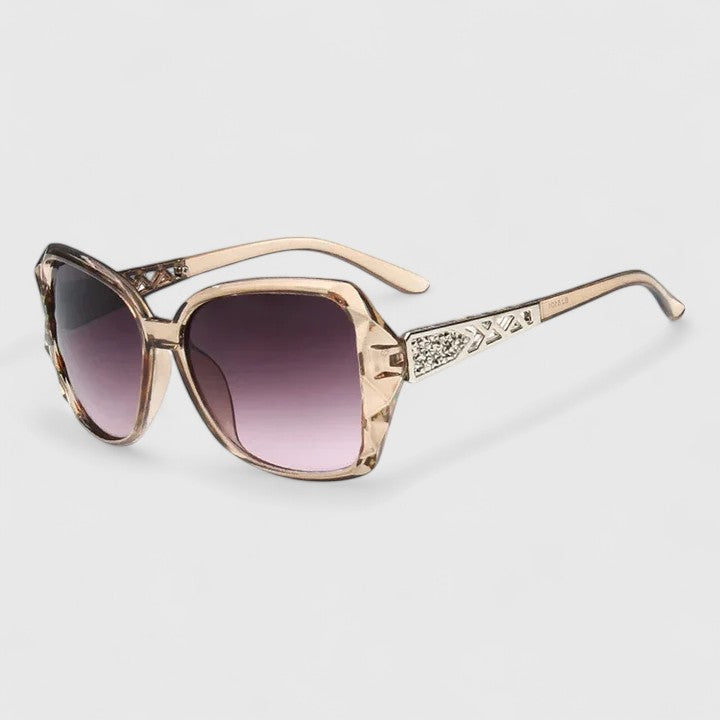 A woman on a sunny city street wearing chic square-frame sunglasses, smiling confidently.