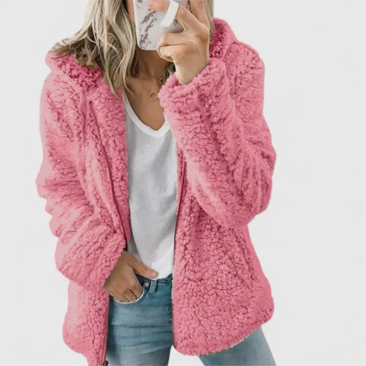 A woman wearing a plush cosy zip jacket over jeans on a cold winter morning.