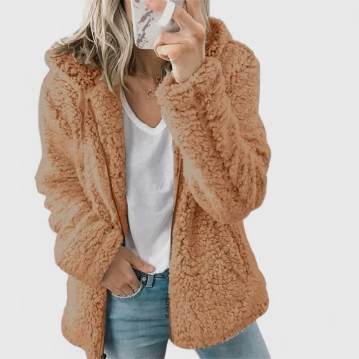 A woman wearing a plush cosy zip jacket over jeans on a cold winter morning.