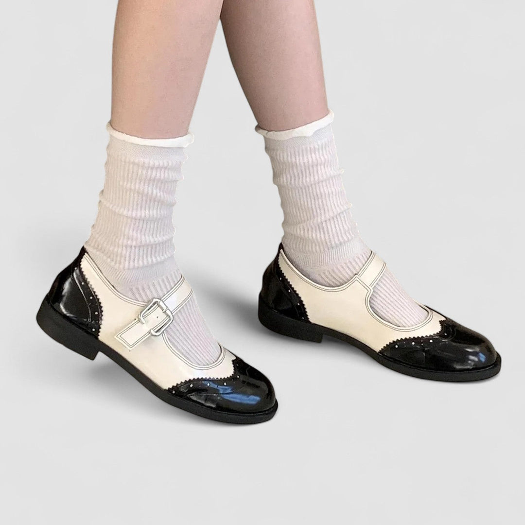 A woman wearing two-tone black and cream Mary Jane shoes, steady and comfortable on an evening out.