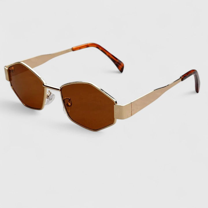 A woman wearing retro hexagonal metal-frame sunglasses on a sunny street.