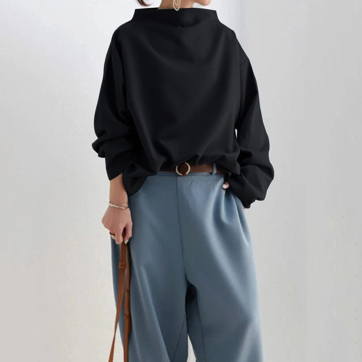 A woman wearing a soft funnel neck sweater styled with jeans for a relaxed elegant look.