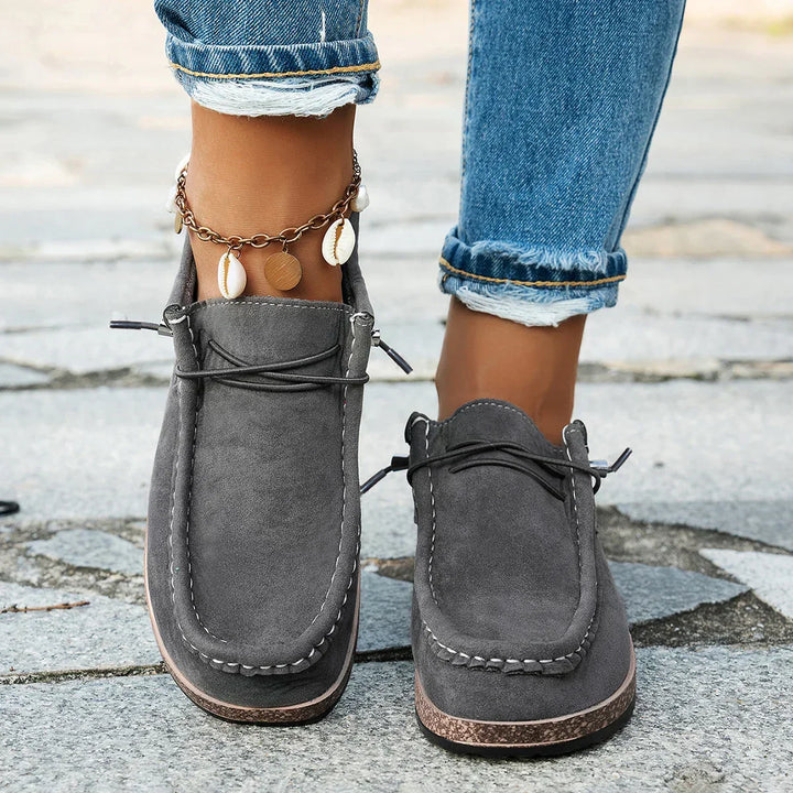 A woman wearing soft grey lace-up platform comfort shoes on an everyday walk.