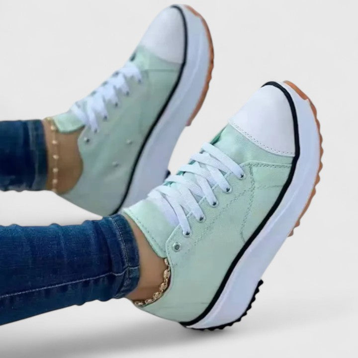 A woman in bold lace-up platform comfort sneakers styled with jeans.