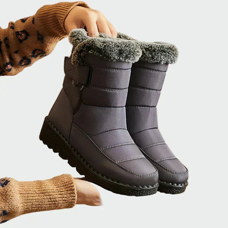 A woman on a frosty morning wearing warm deep navy winter boots with a grippy sole.