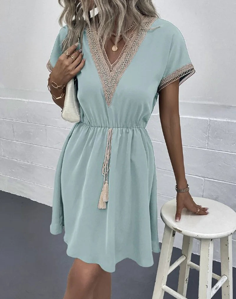 A woman wearing a relaxed boho dress with fringe accents and delicate openwork detailing.