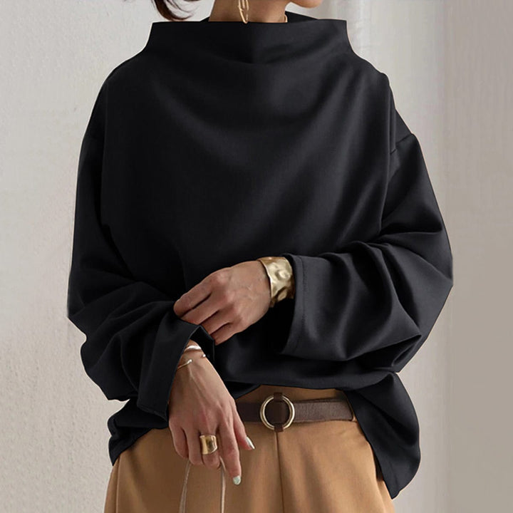 A woman wearing a soft funnel neck sweater styled with jeans for a relaxed elegant look.