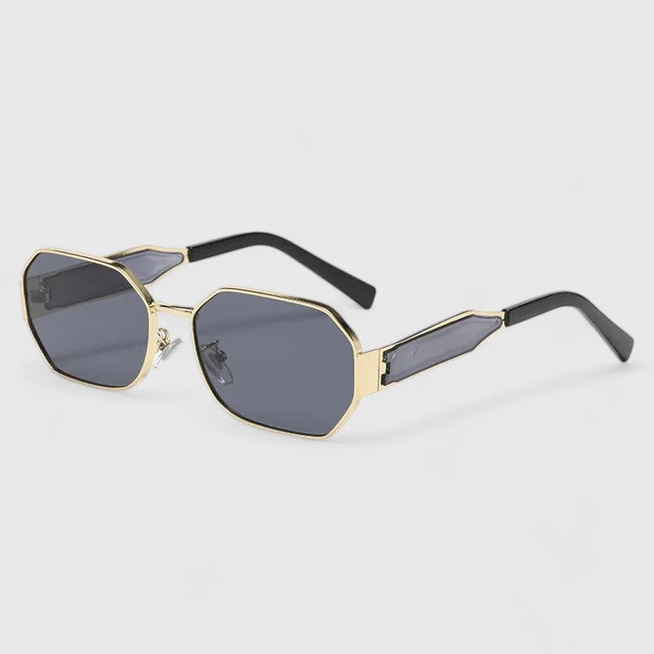 A woman wearing bold geometric gold-accented sunglasses with gradient lenses on a bright day.