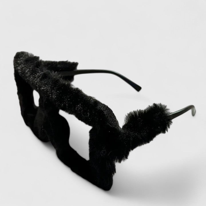 A bold pair of sunglasses with a soft red fluffy trim around the frame and slim black arms.