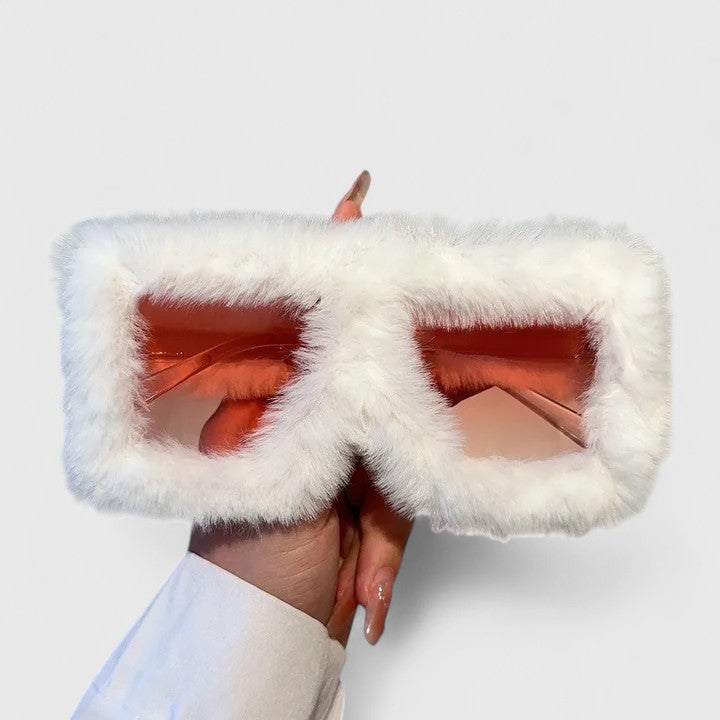 A bold pair of sunglasses with a soft red fluffy trim around the frame and slim black arms.