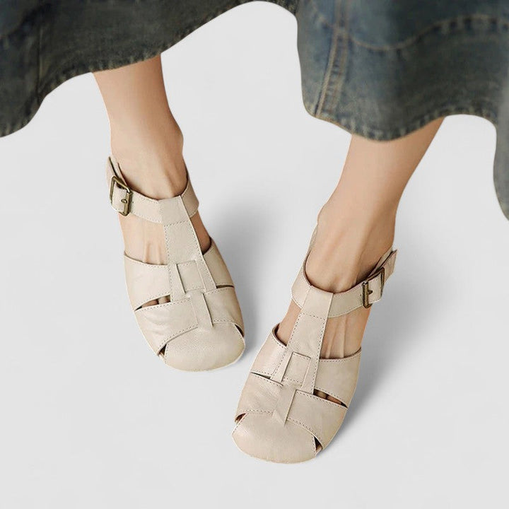 A woman in burgundy closed-toe woven sandals with a low block heel, comfortable browsing a market.