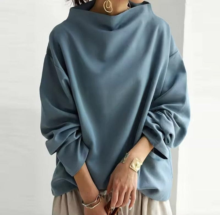 A woman wearing a soft funnel neck sweater styled with jeans for a relaxed elegant look.