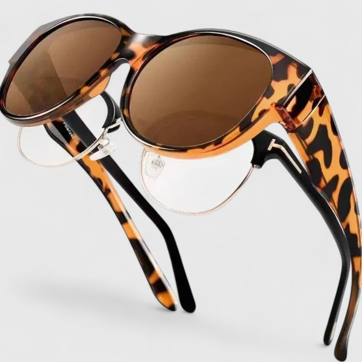 A woman wearing fit-over polarised sunglasses over her own glasses, comfortable in the sunshine.