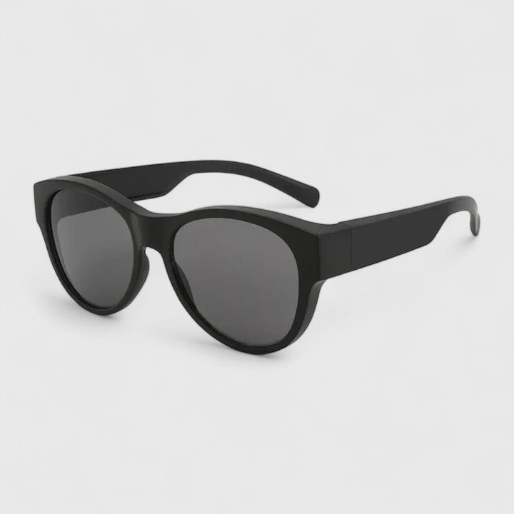 A woman wearing fit-over polarised sunglasses over her own glasses, comfortable in the sunshine.