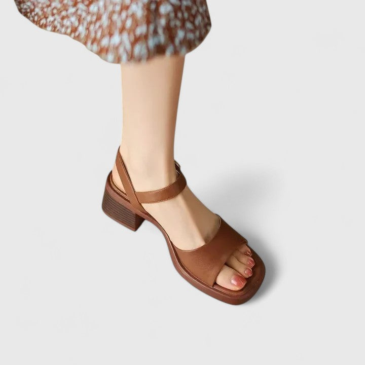 A woman in brown block heel sandals with an ankle strap, dressed for the day.