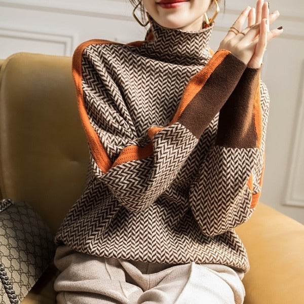 A woman wearing a brown and beige chevron high-collar sweater with bright green side stripes.
