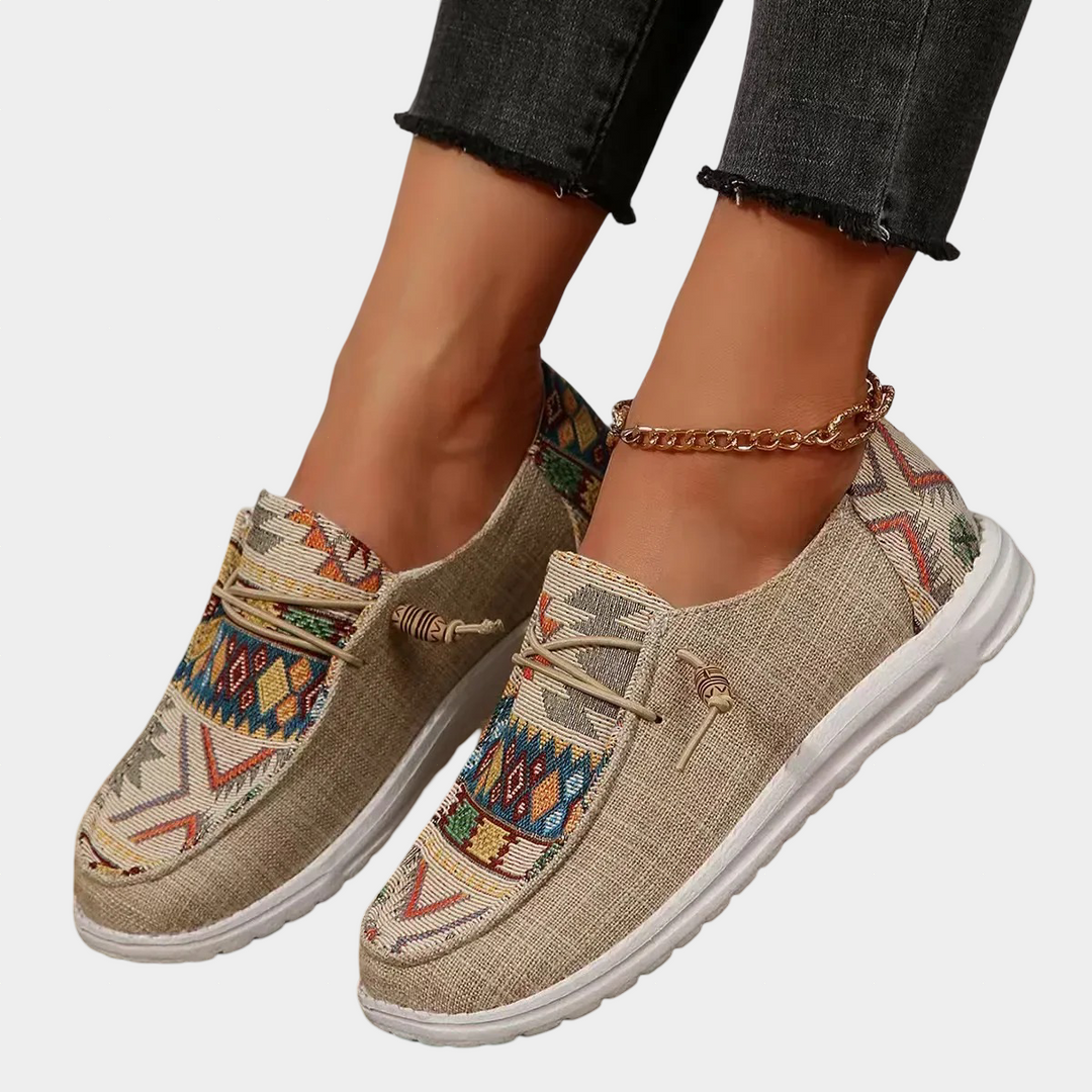 A woman wearing warm light brown boho-print lace-up comfort shoes on a country walk.