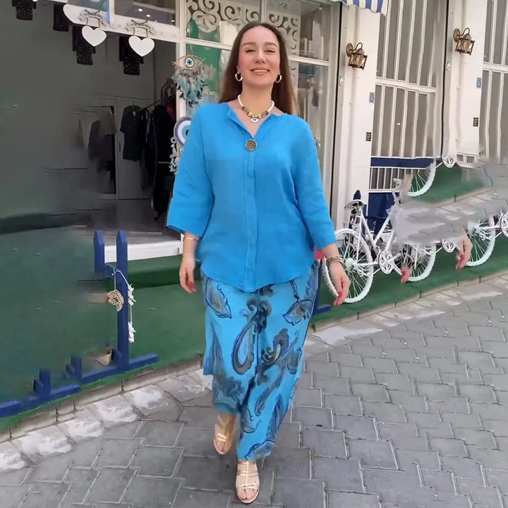 A woman wearing a bright blue blouse with matching patterned wide-leg pants