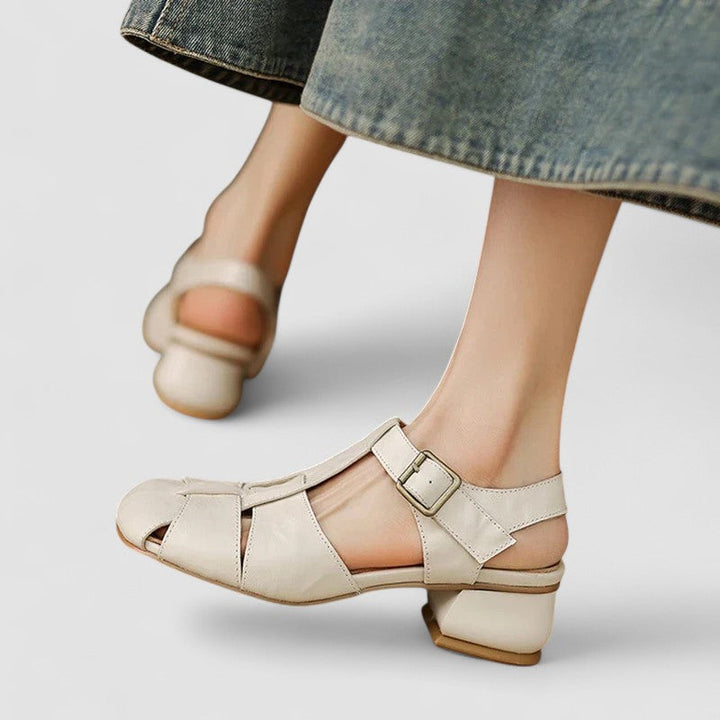A woman in burgundy closed-toe woven sandals with a low block heel, comfortable browsing a market.