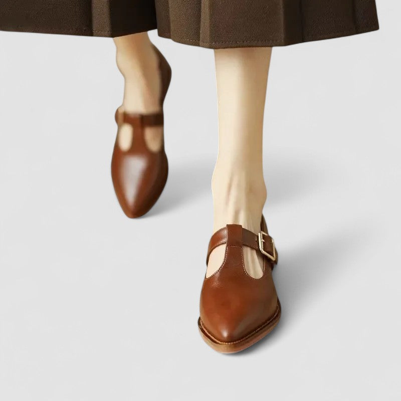 A woman in beige Mary Jane shoes with a mid block heel, poised at a daytime wedding.